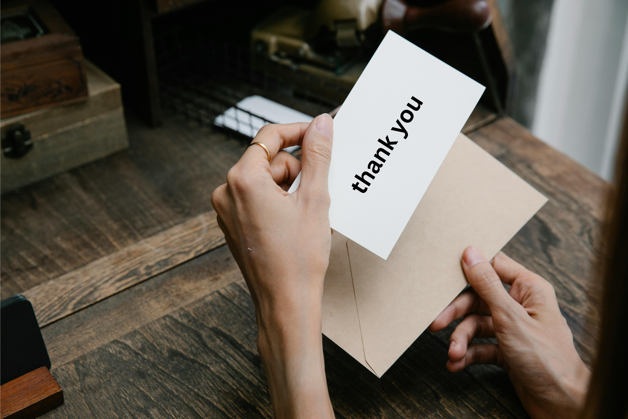 Professional sales representative reviewing handwritten thank you card in B2B Selling Weapon before sending to business contact with personalized message